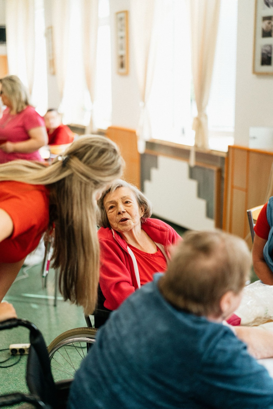 A care worker leaning in to talk with a resident during an activity