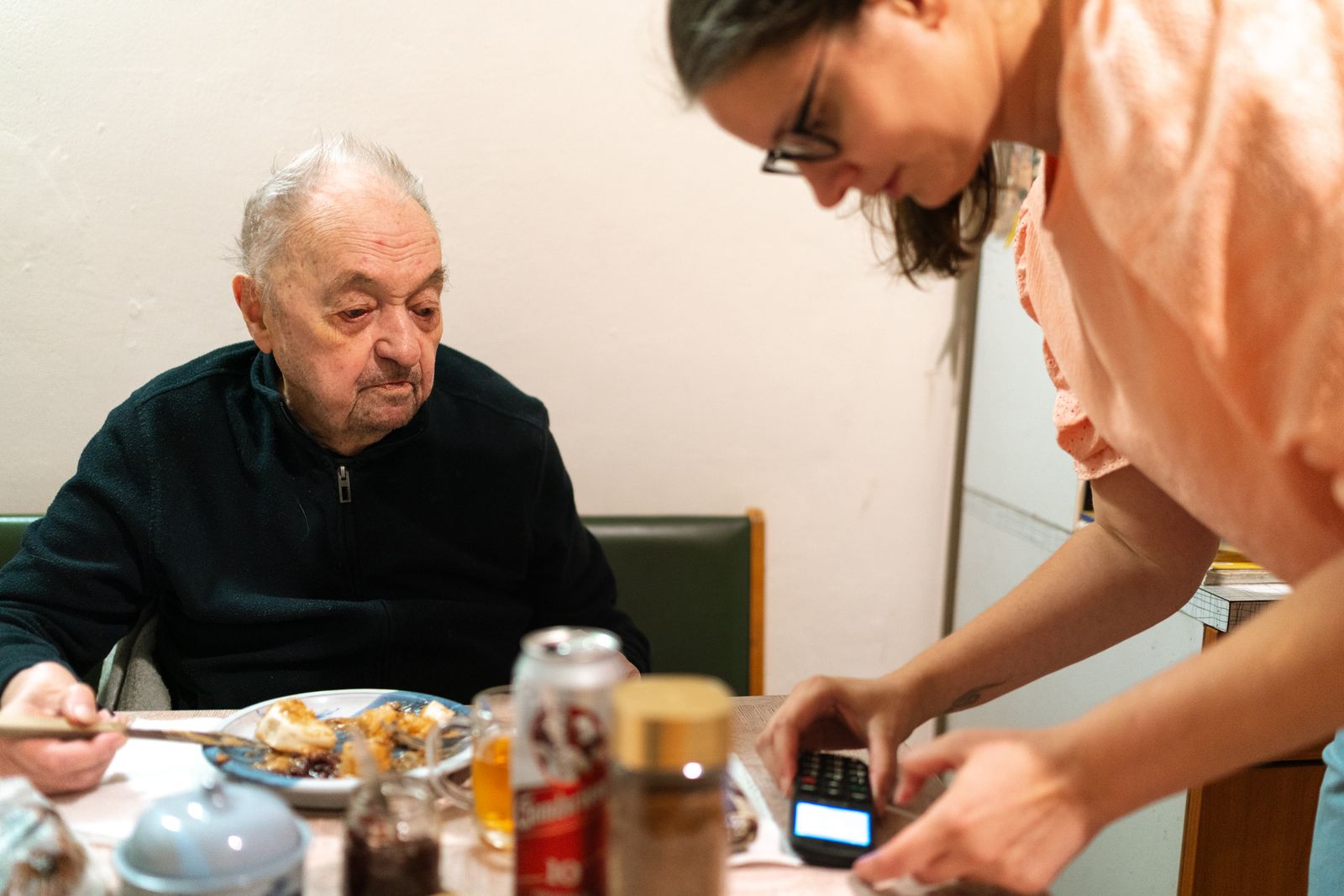 A PowerCare carer helping an older man at breakfast during a home visit
