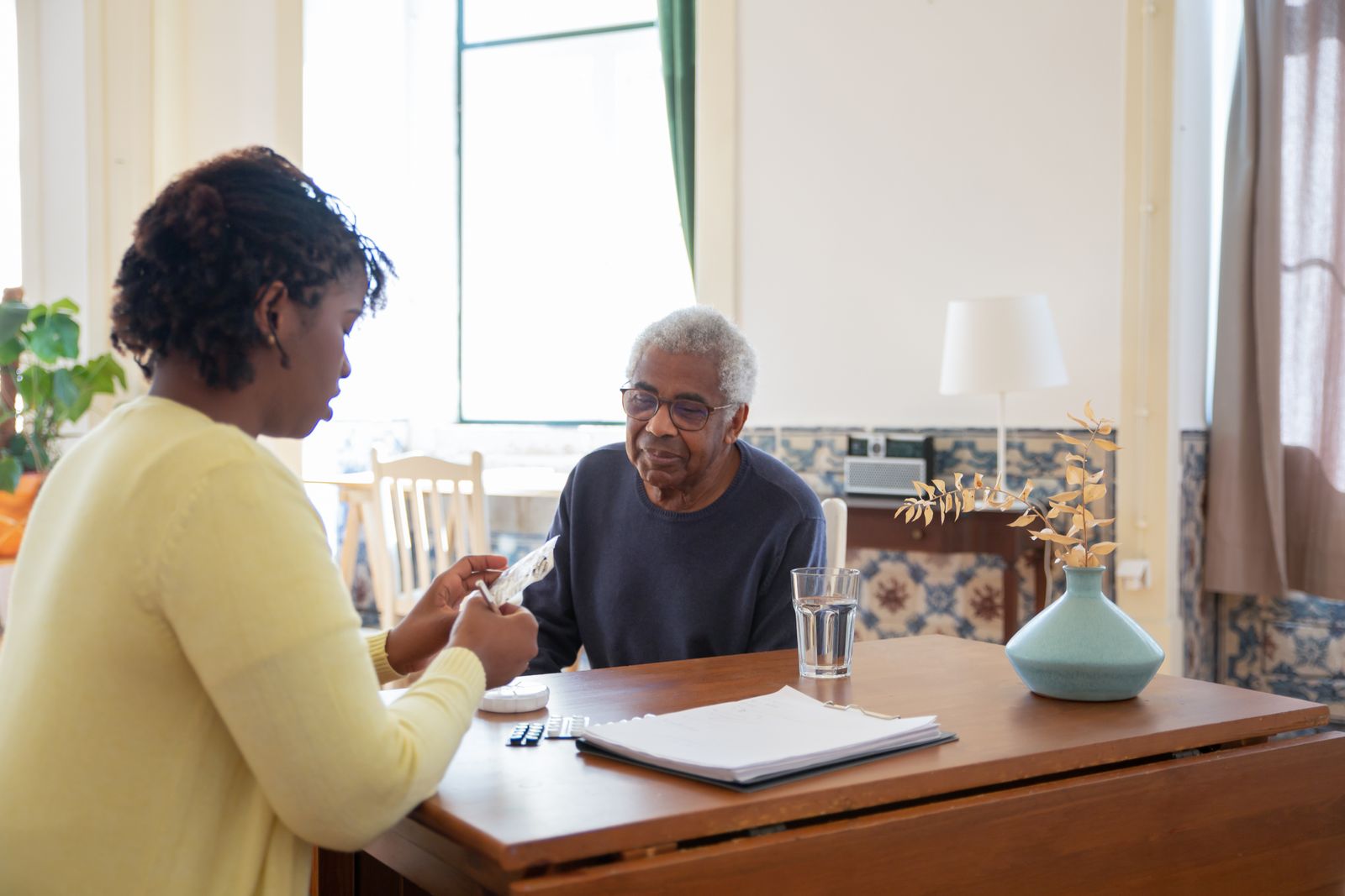 A carer going through the day’s plans with an older man at home