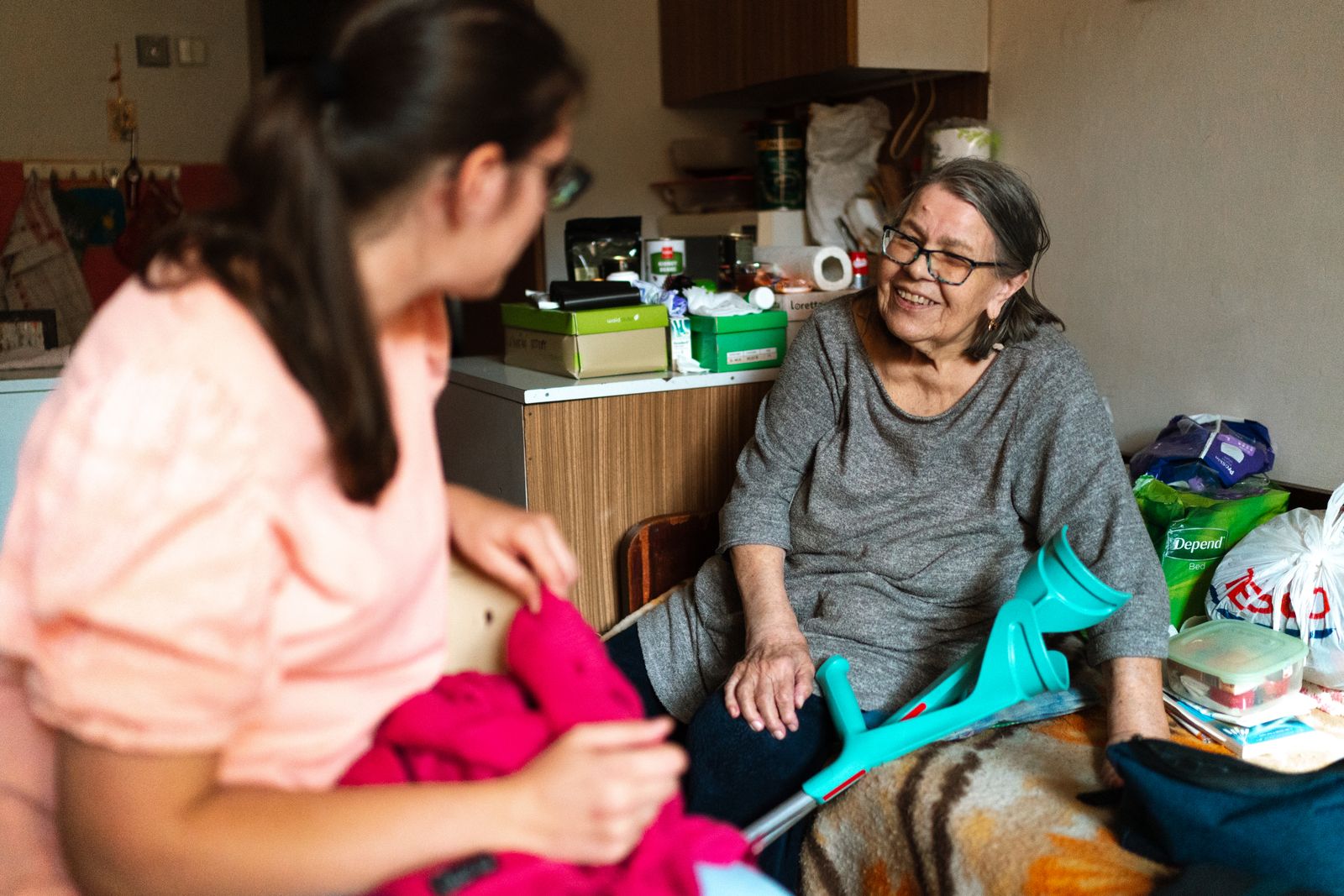 A PowerCare carer sitting with an older woman on her sofa
