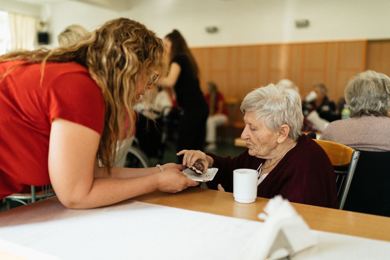 A care worker playing cards with a resident at the table