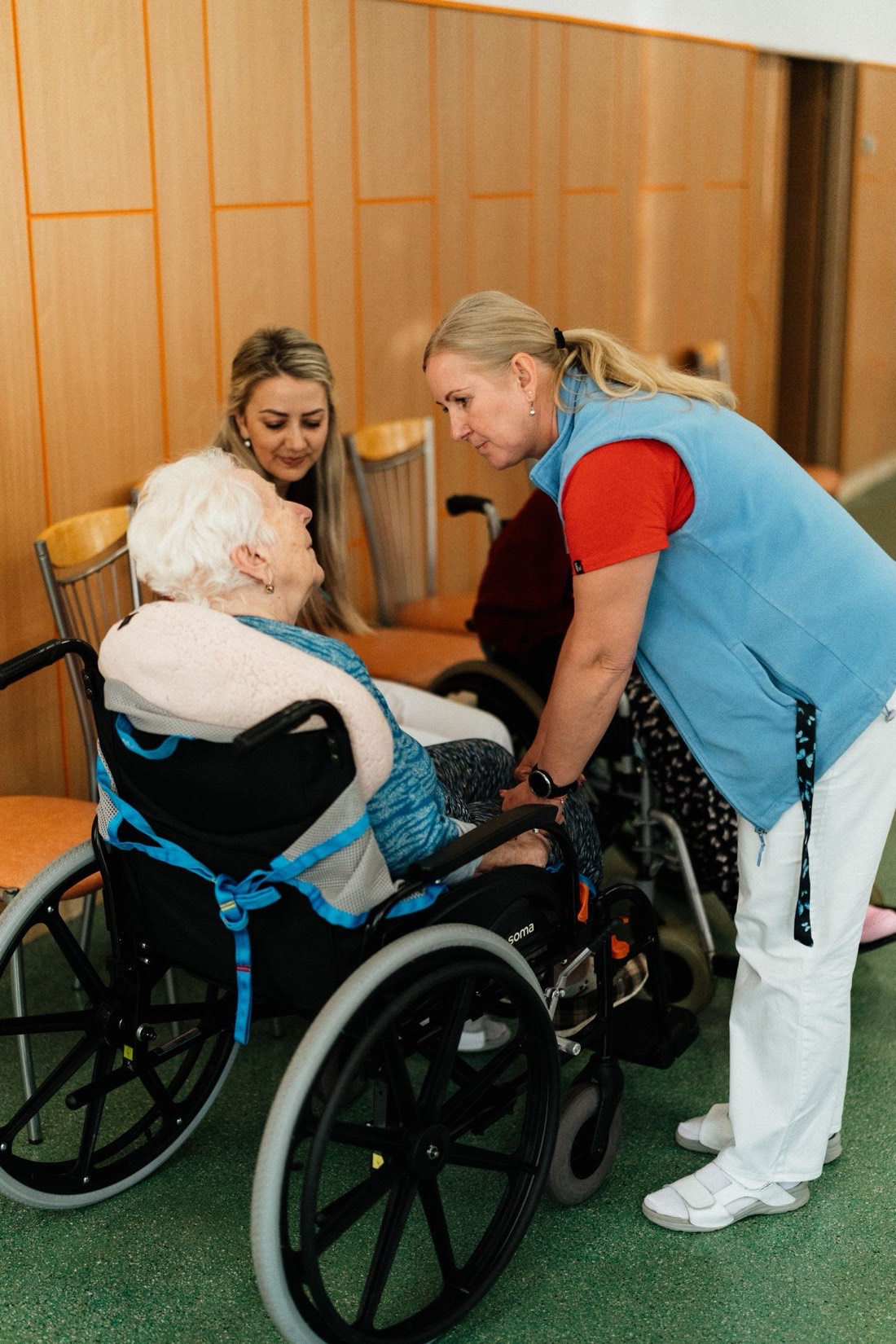Care workers helping a resident in a wheelchair